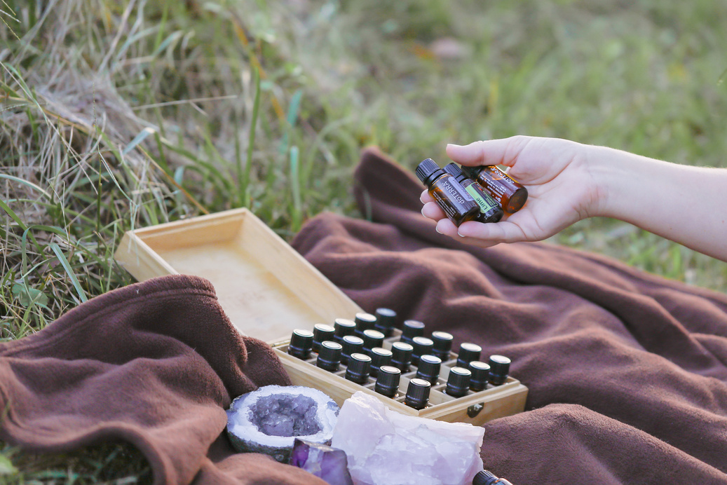Firefly NSW Australia - 20 April 2022: Collection of Doterra Essential Oils on Picnic Rug with Woman's Hand